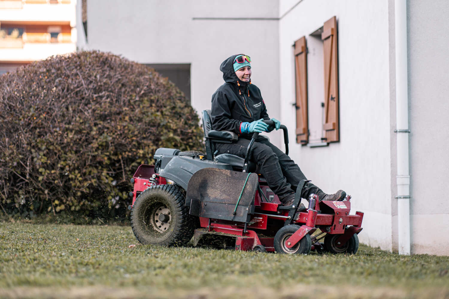 Photo d'une paysagère entrain de tondre une pelouse
